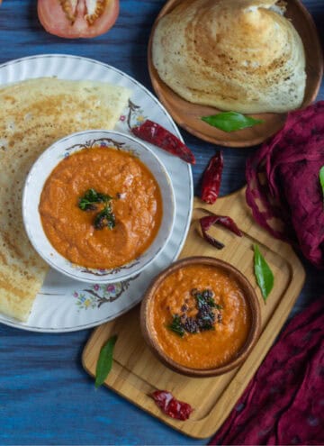 tomato chutney in a wooden bowl and in a ceramic bowl served with dosa