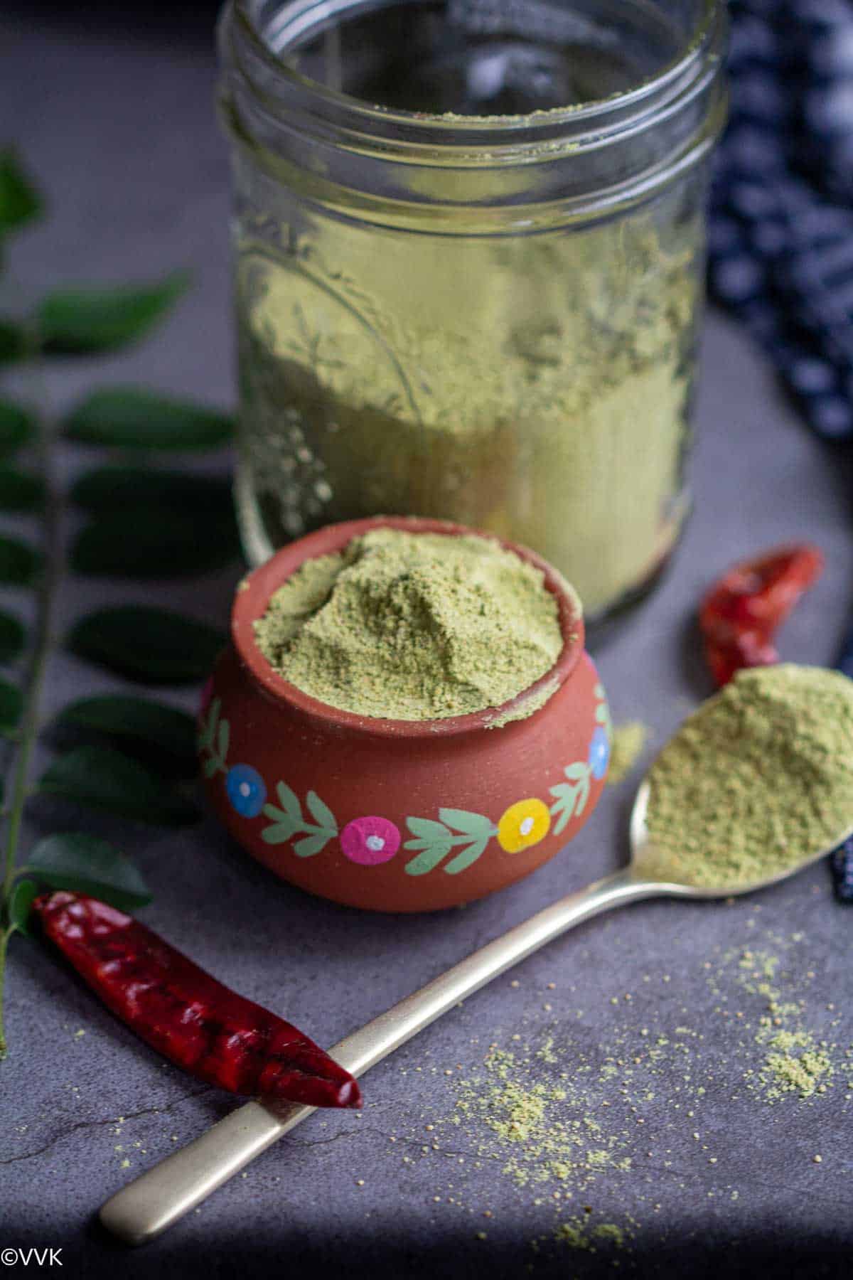 curry leaves spice mix served in small mud pot with another batch in a mixer jar