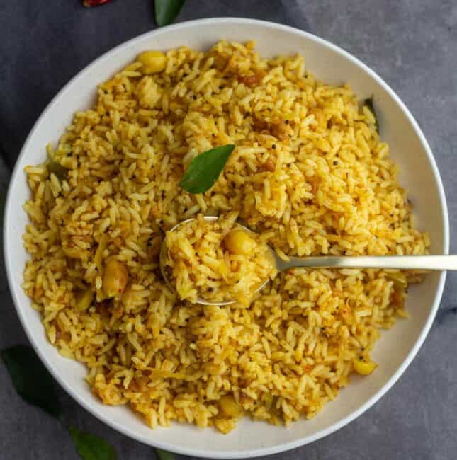 square image of raw mango rice served in white plate with spoonful of rice