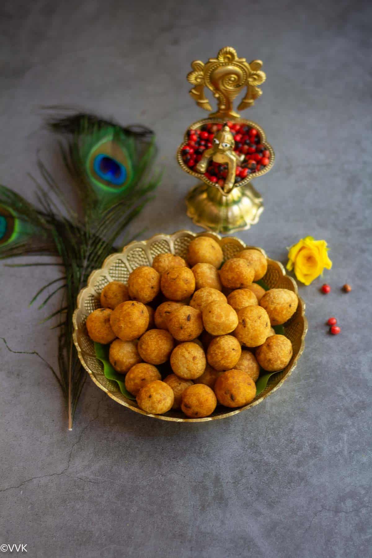 uppu seedai served in bronze plate with krishna lamp on the side with peacock feathers