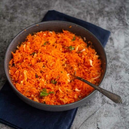 square image carrot coconut salad served in gray bowl