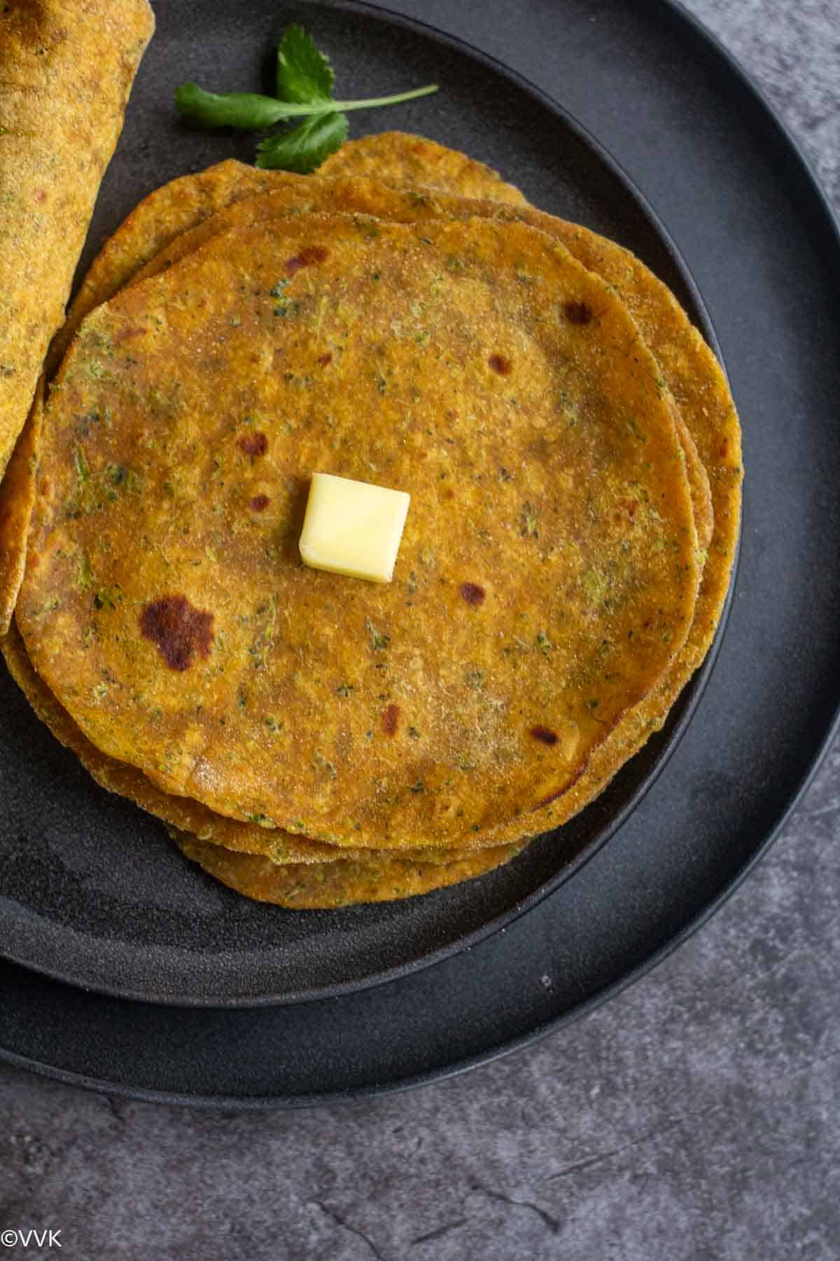 overhead shot of broccoli paratha shot and rolled ones on the side