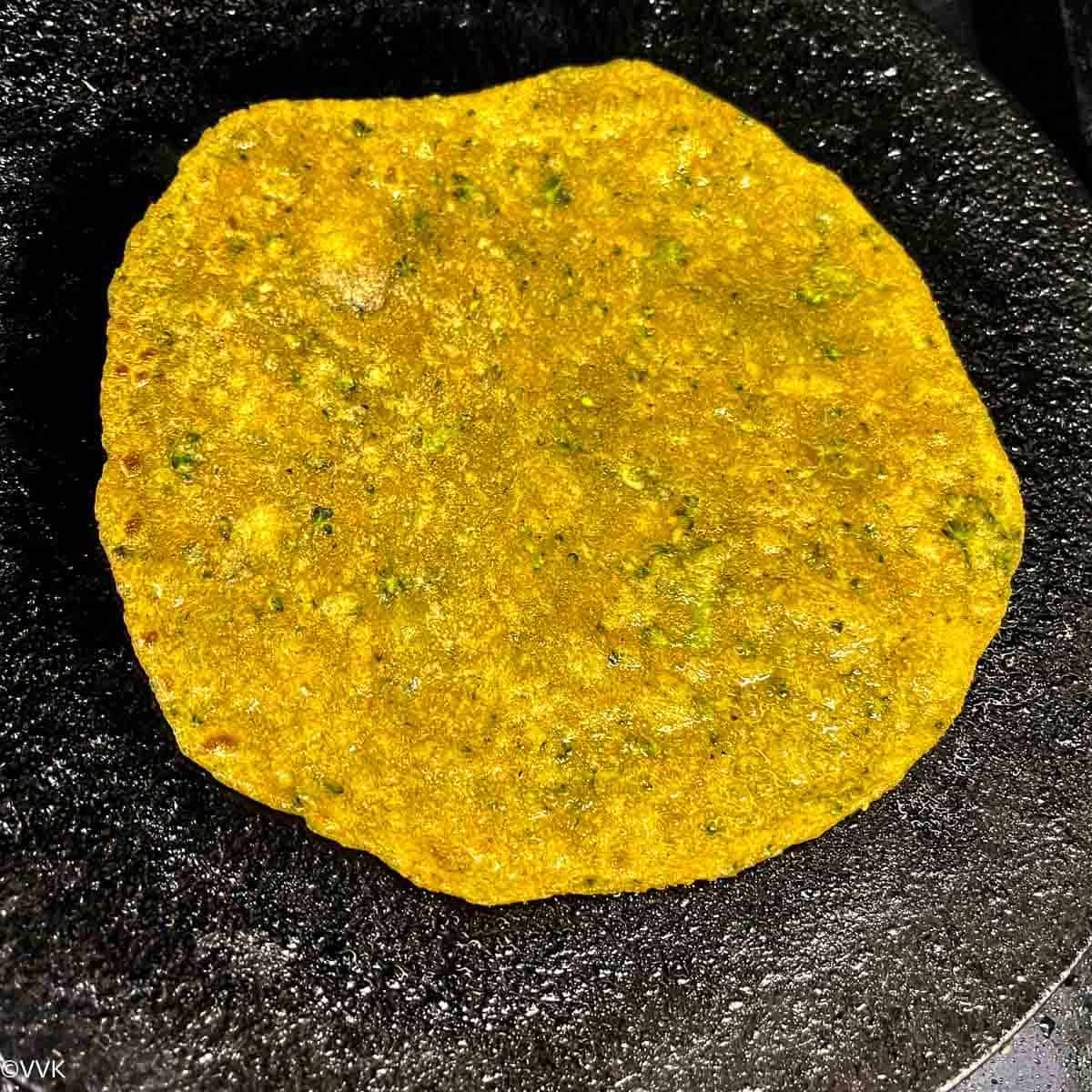 flipping the paratha and cooking
