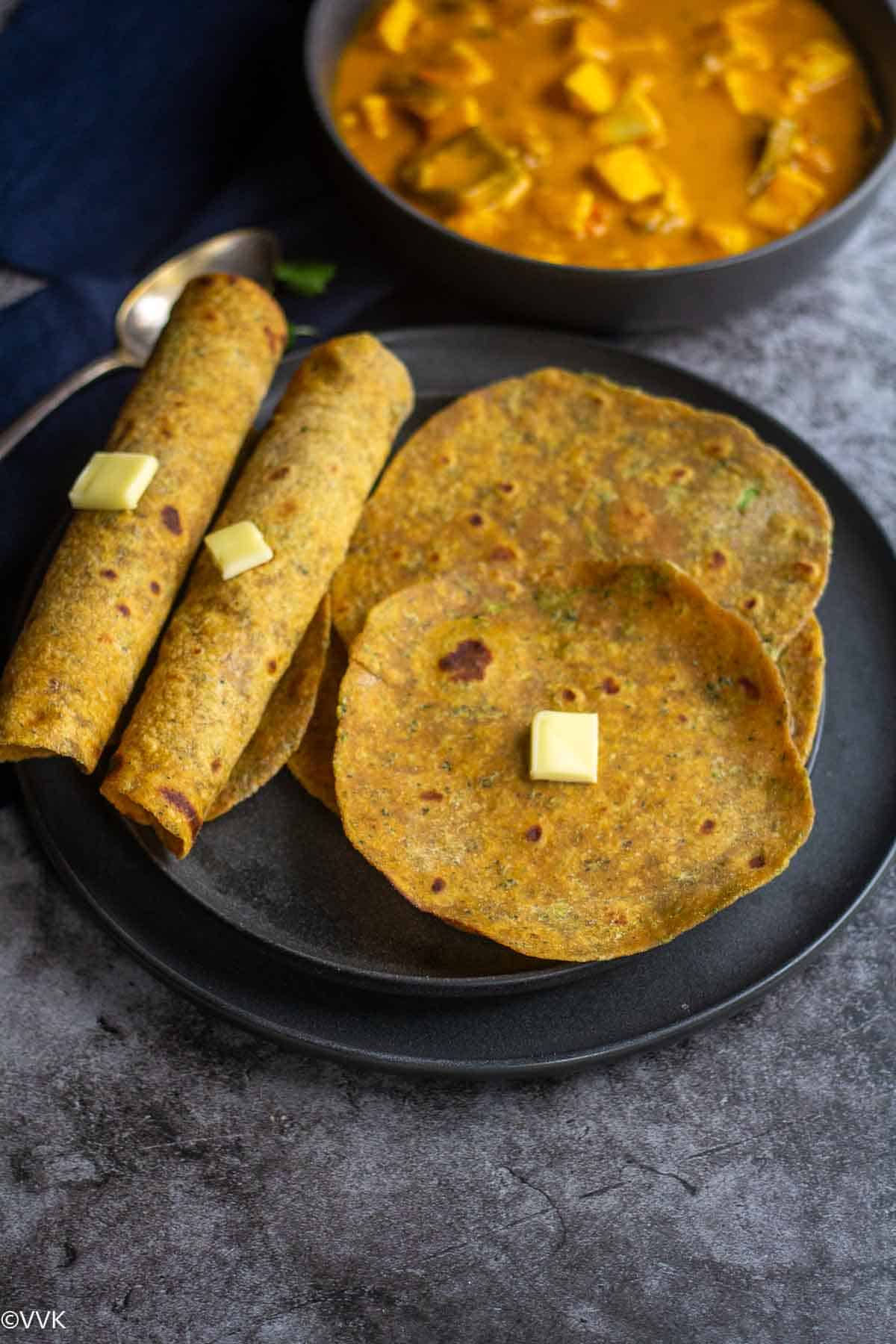overhead shot of broccoli paratha shot and rolled ones with paneer on the side