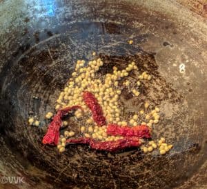 Adding mustard seeds, urad dal and dried red chilies