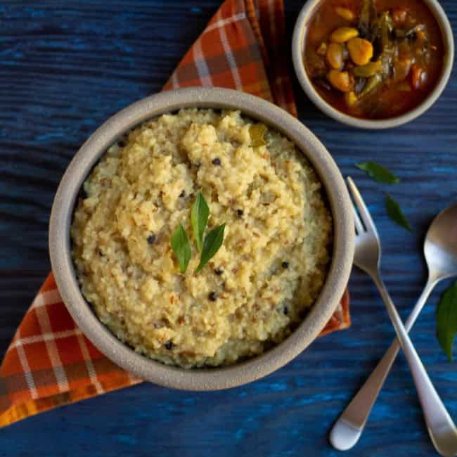 quinoa and millet ven pongal on a clay bowl with gojju on the side