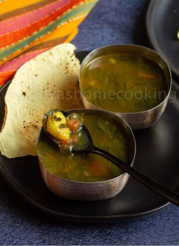 square image of moringa rasam served in two silver ware