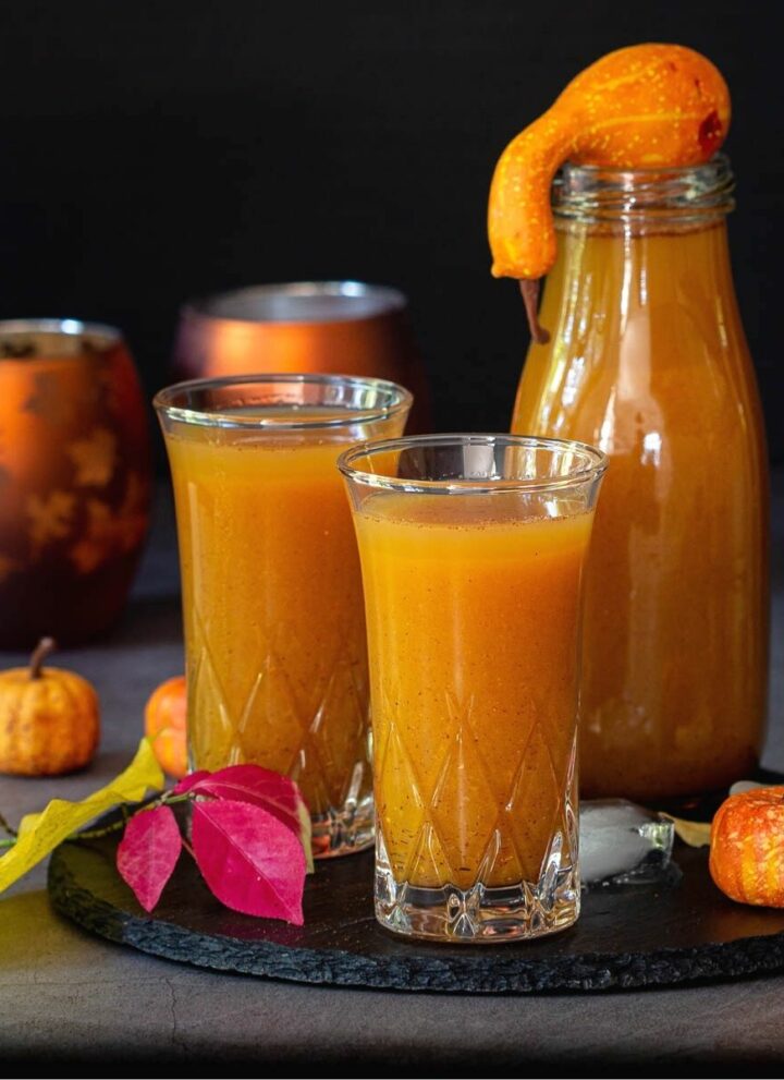 square image of pumpkin juice served in two glasses and in one bottle