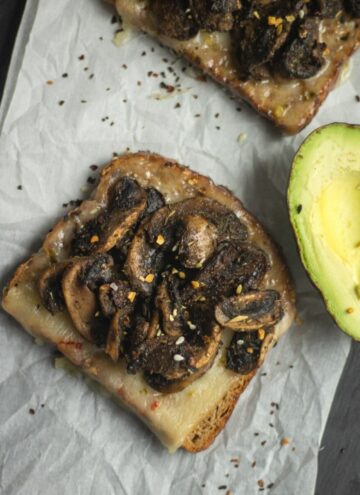 mushroom toast served with avocado placed on a parchment paper