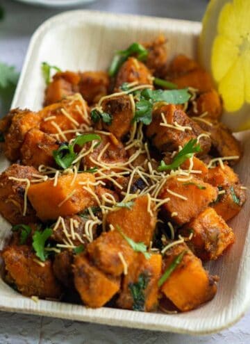 square image of sweet potato chaat served in leaf plate