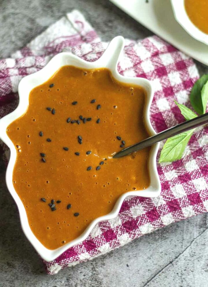 square image of thai peanut sauce served in leaf bowl