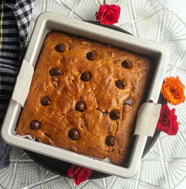 chocolate chip cake right out of oven in the pan with roses on the side