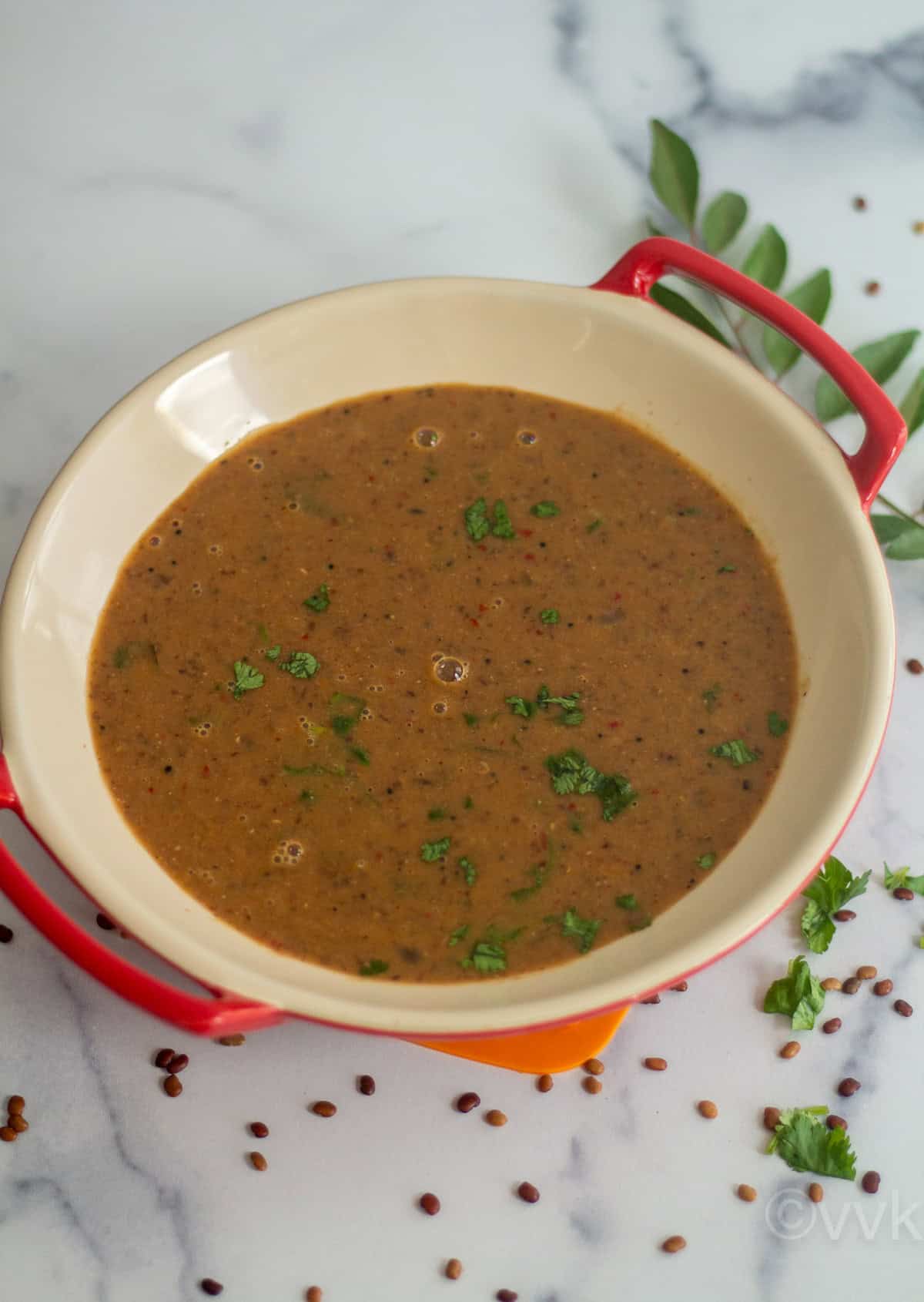 simple kollu kdayal served in red ceramic ware with curry leaves on side
