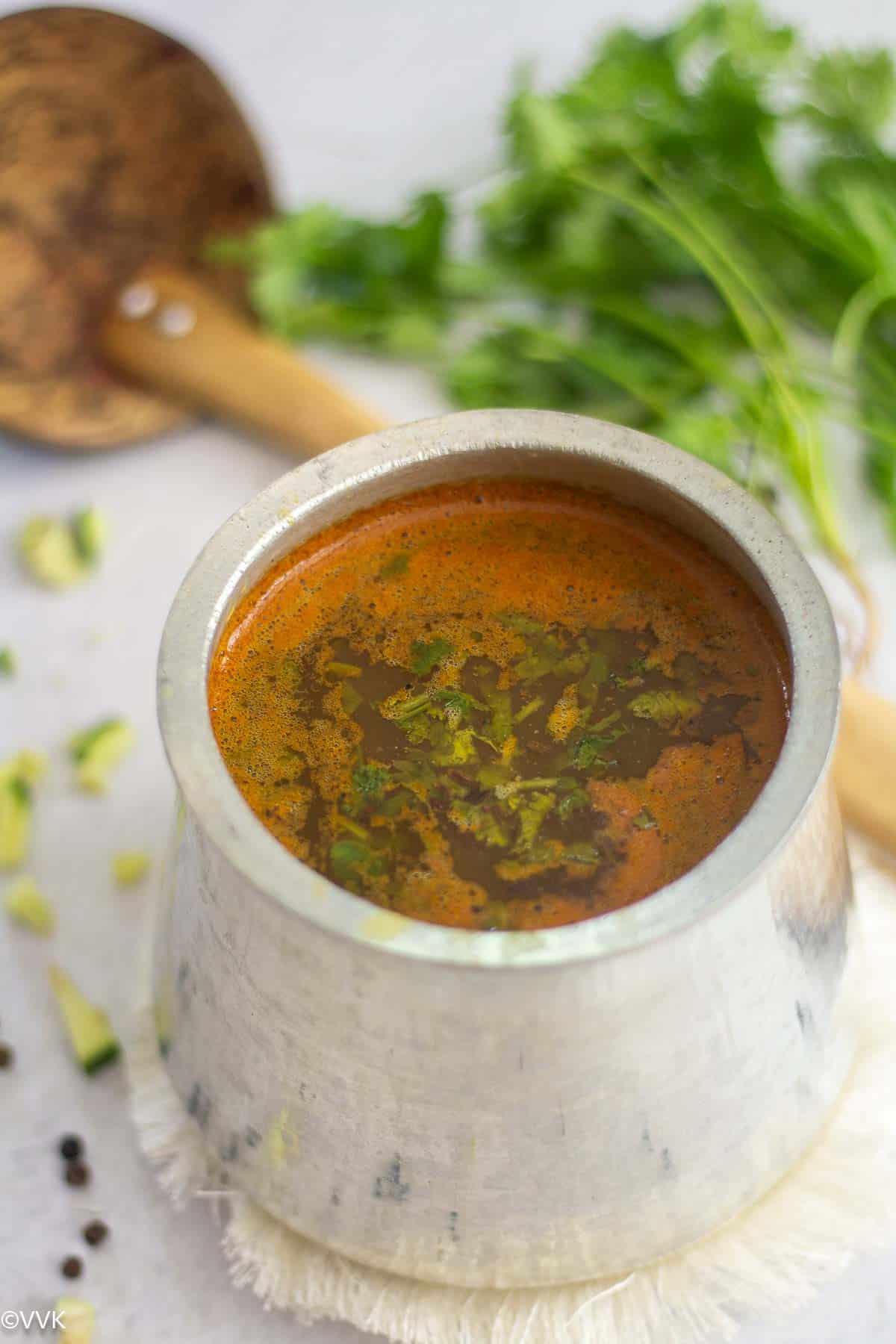 close up shot of mango rasam served in eeya sombu