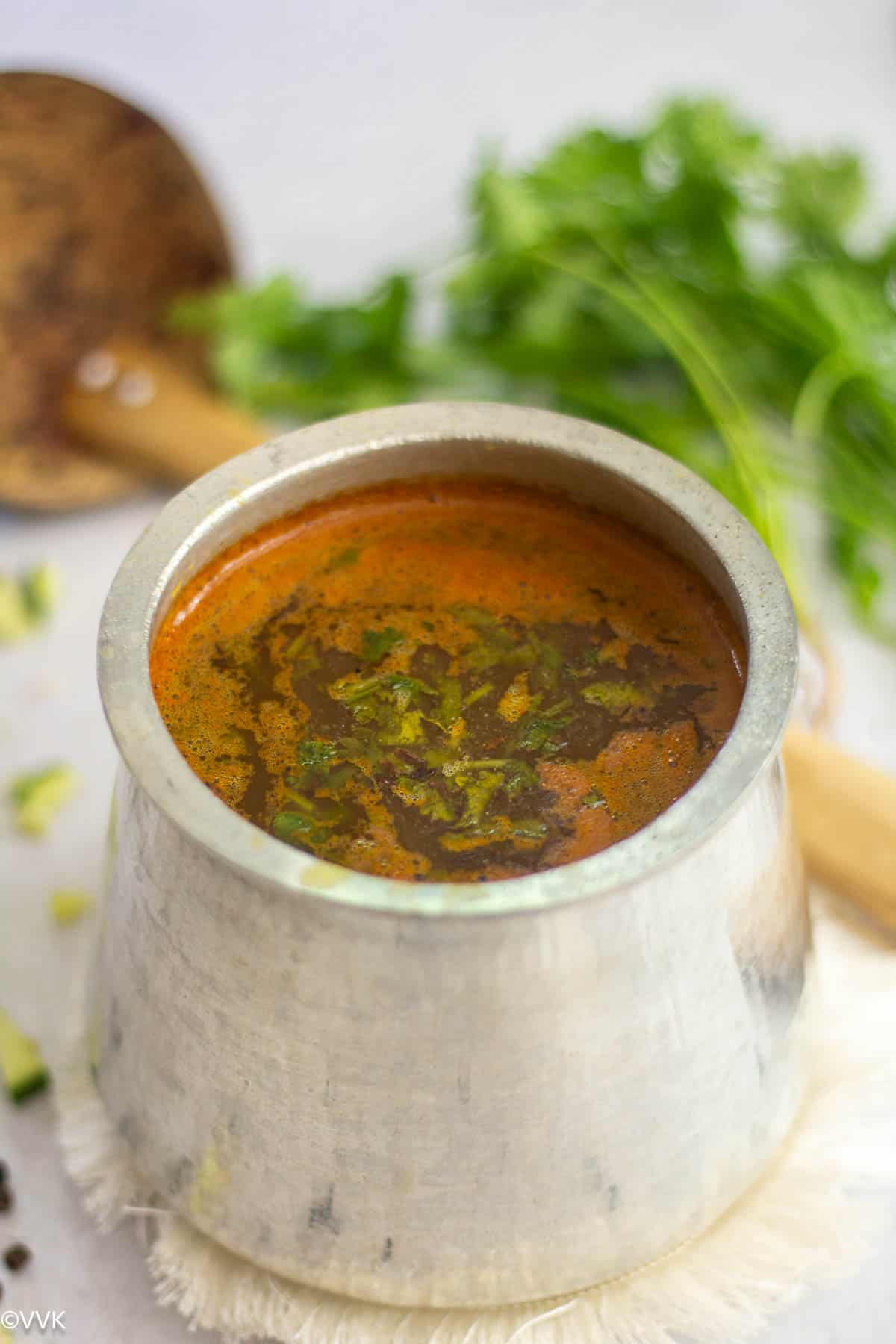 south indian rasam with raw mangoes served in eeya sombu 