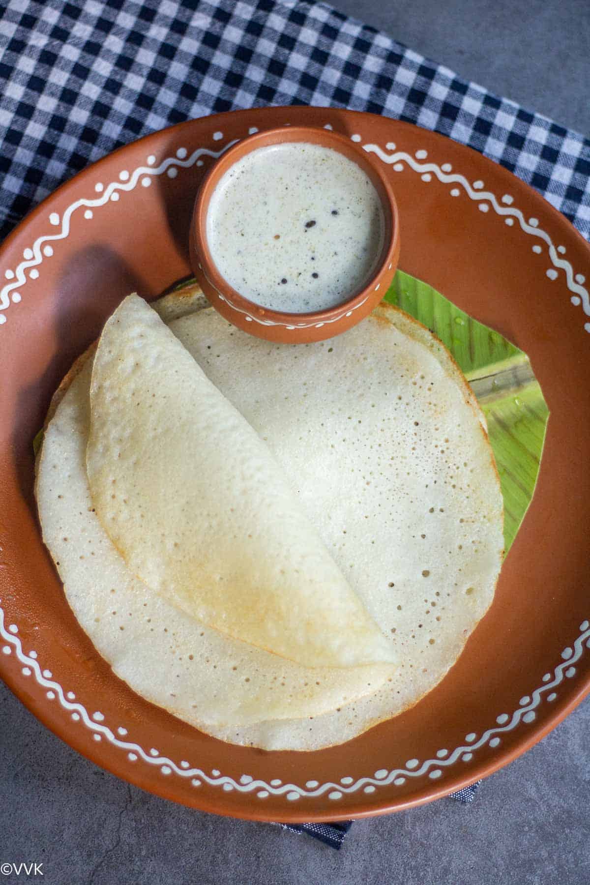 one water melon dosa folded and placed on top of another with side of chutney