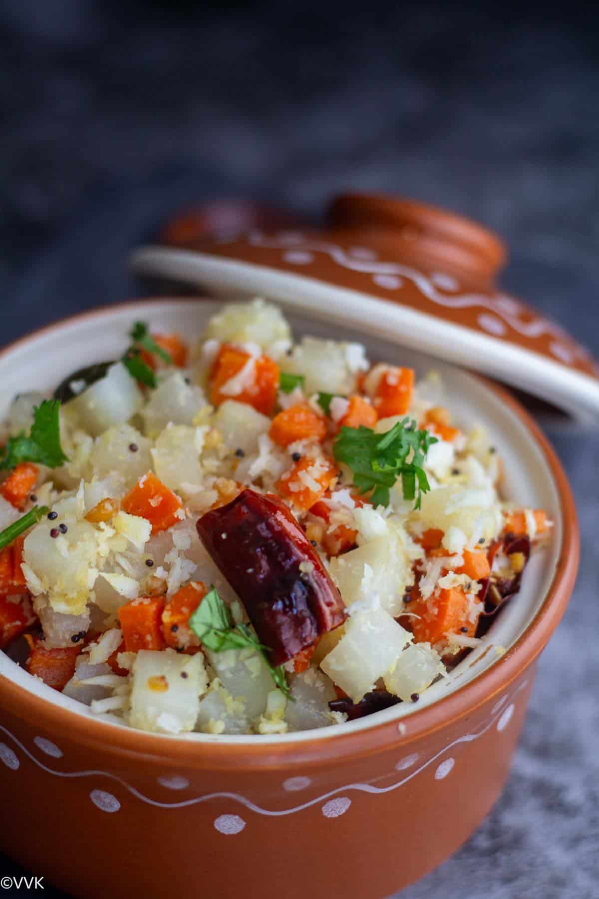 close up shot of carrot radish poriyal in terracotta serveware