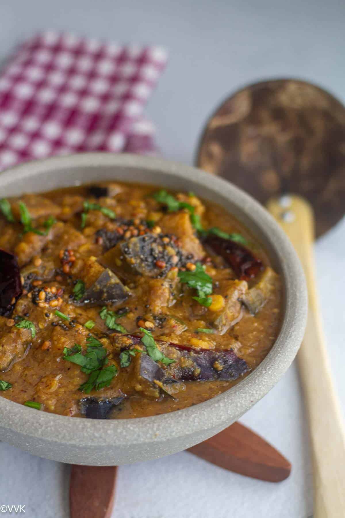 slanting shot of rasavangi placed on wooden trivet with spoon on the side