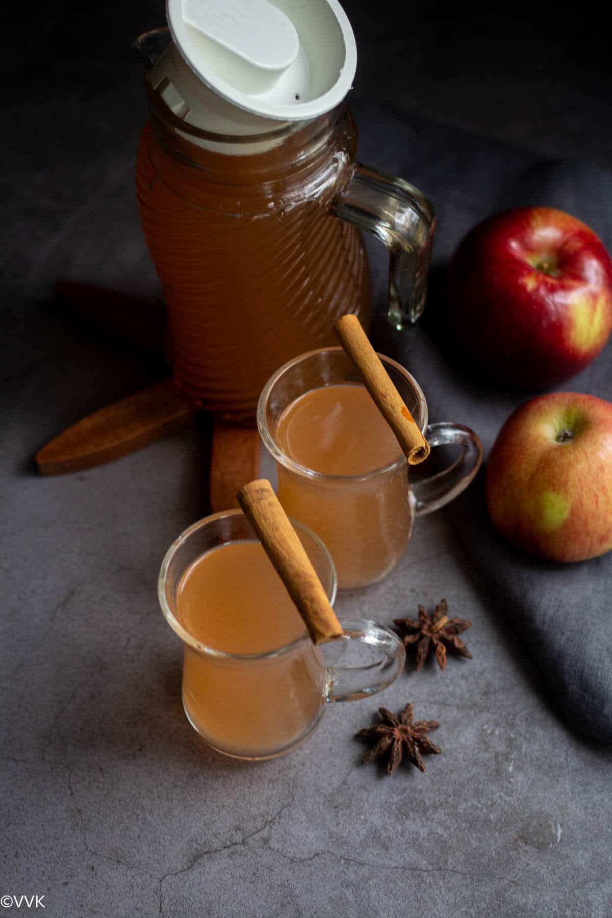 homemade cider with apple served in glasses with cinnamon on top