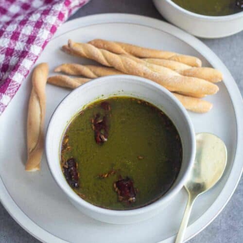 square image of moringa soup served in white bowl.