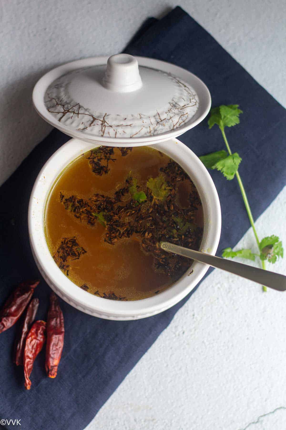 overhead shot of vepampoo rasam served in white bowl