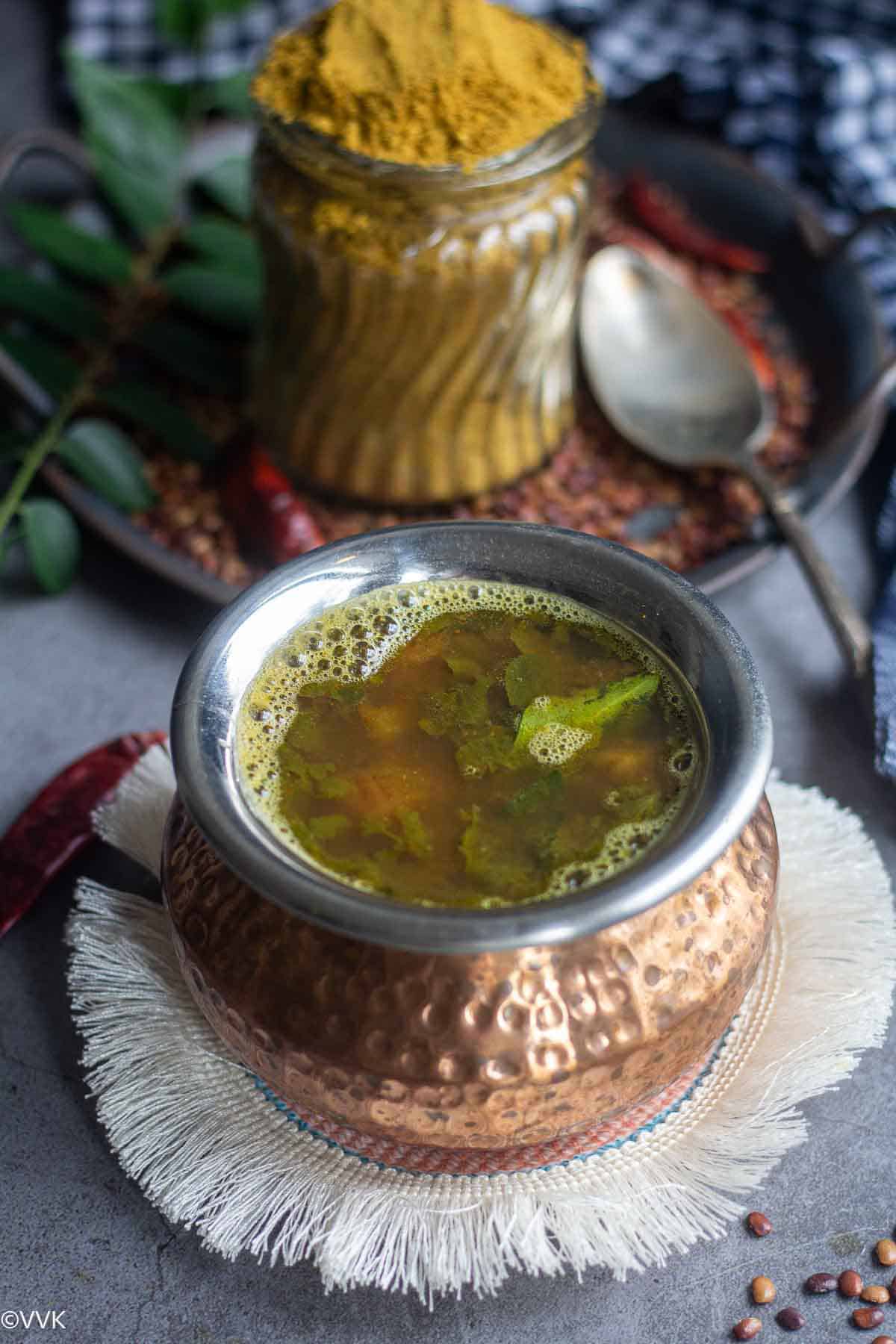 easy horsegram lentil rasam served in traditional ware with spice mix on the side