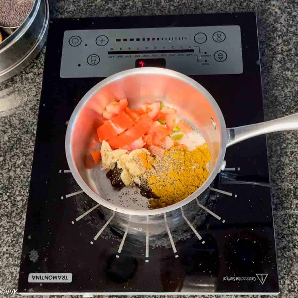 adding all the ingredients for kollu rasam in sauce pan