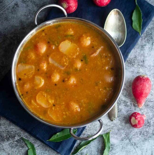 square image of red radish sambar served in kadai