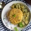 square image of zucchini rice served with kurma and raita