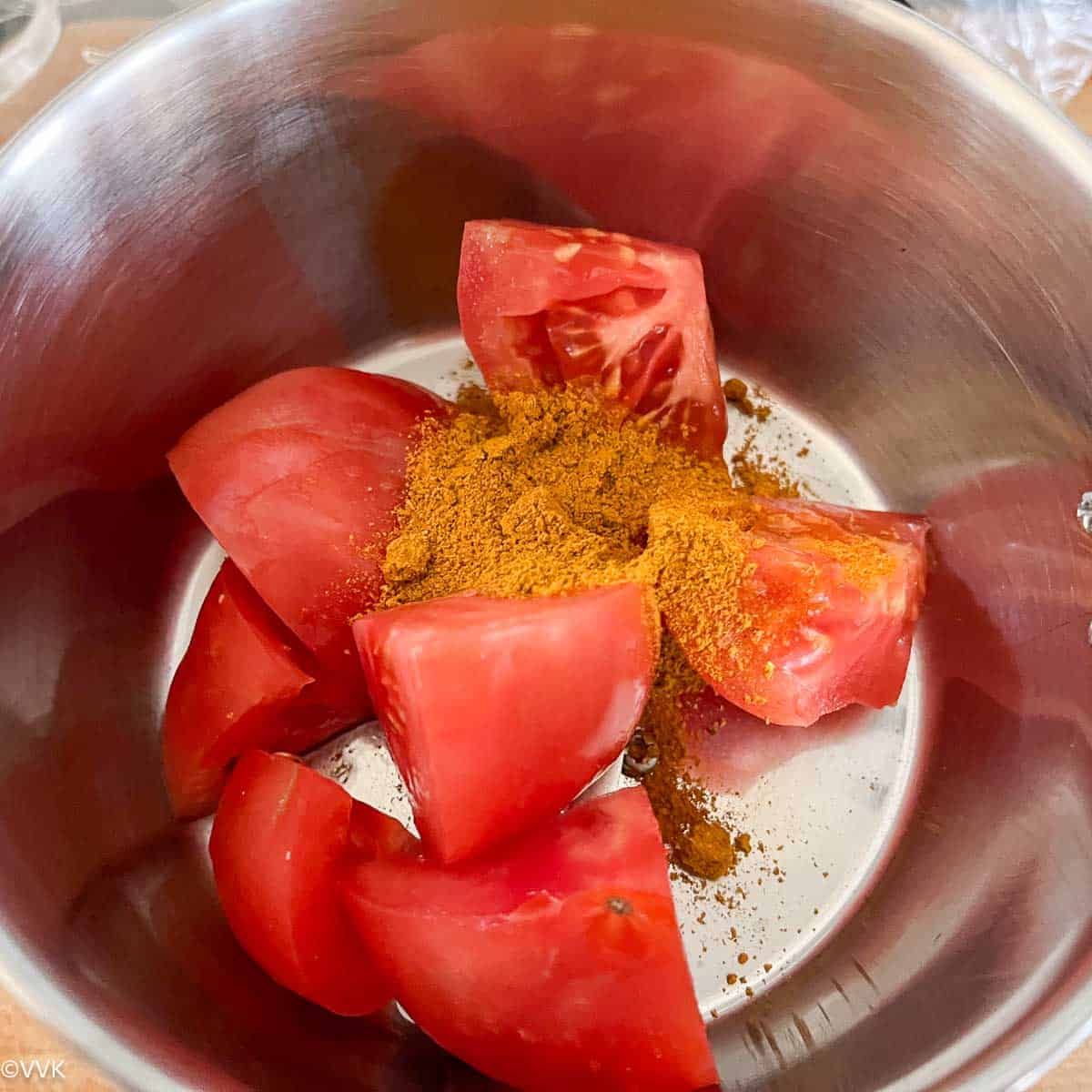 taking tomato and curry powder to mixer jar