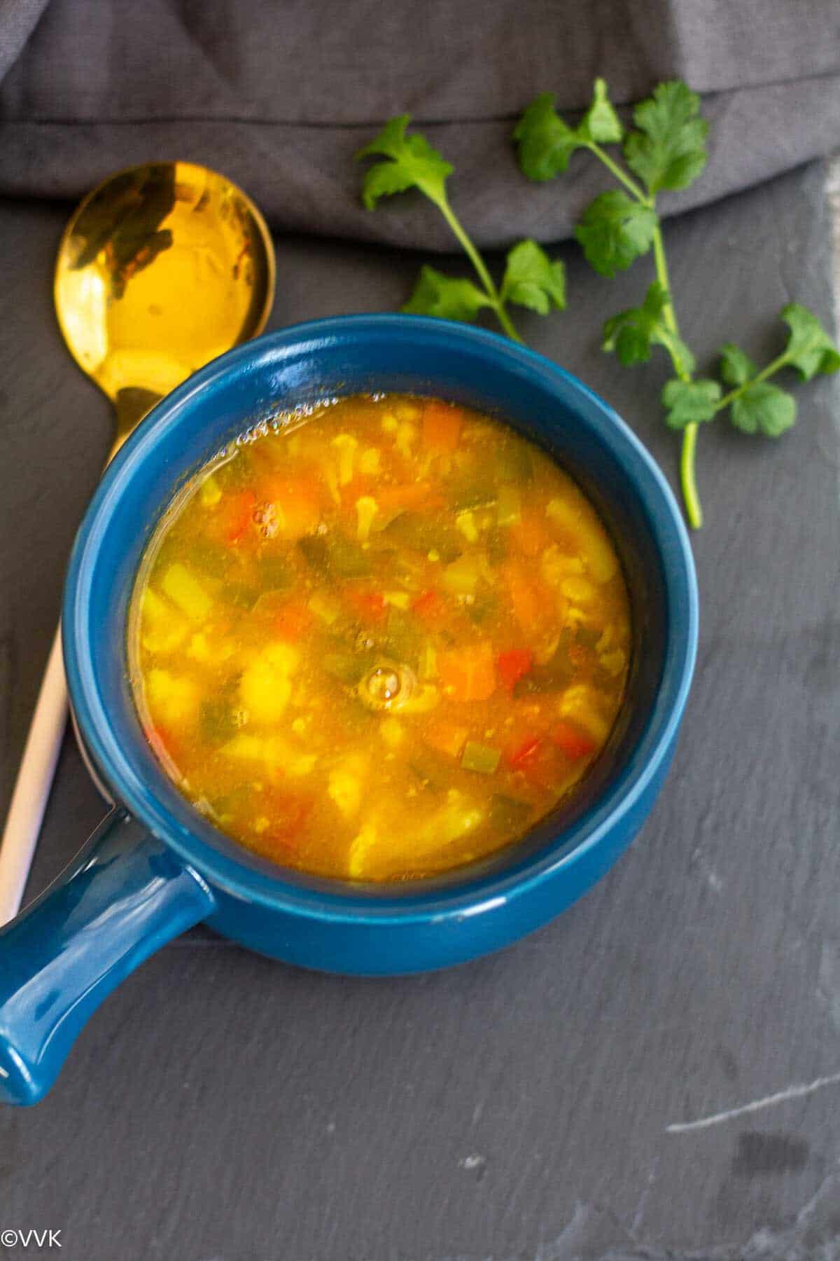 Overhead close up shot of barley soup served in blue crockpot 