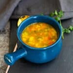 square image of barley soup served in blue soup crock pot